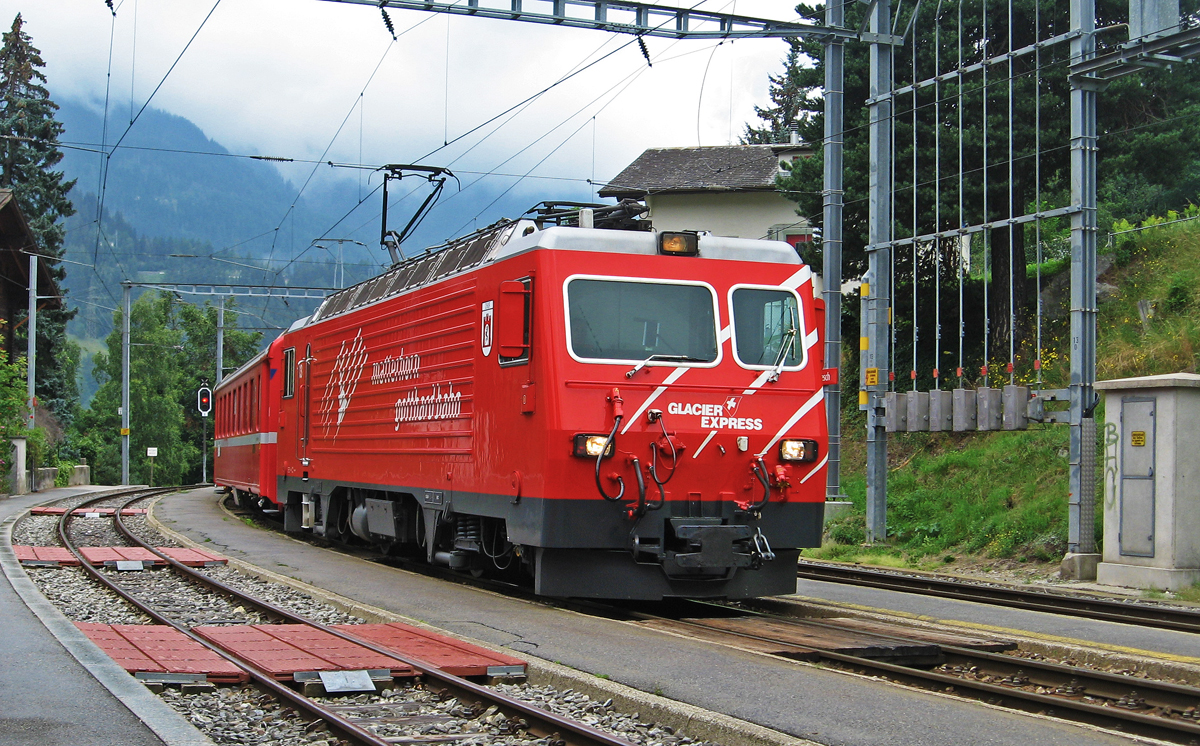 Eine HGe 4/4 II der Matterhorn Gotthard Bahn erreicht mit einem Glacier-Express nach St. Moritz den Bahnhof Fiesch (16.08.2007)