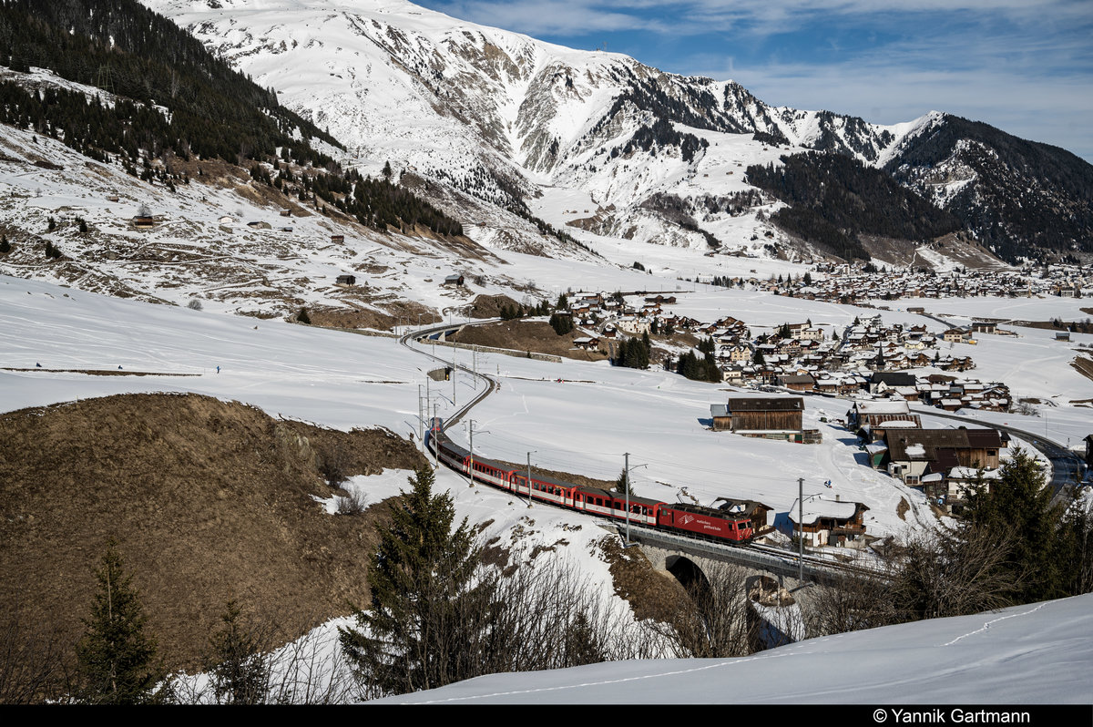 Eine HGe 4/4 II der MGB zieht einen Regionalzug nach Andermatt. Hier auf dem Viadukt vor Dieni (Sedrun). Aufgenommen am 20.02.2020