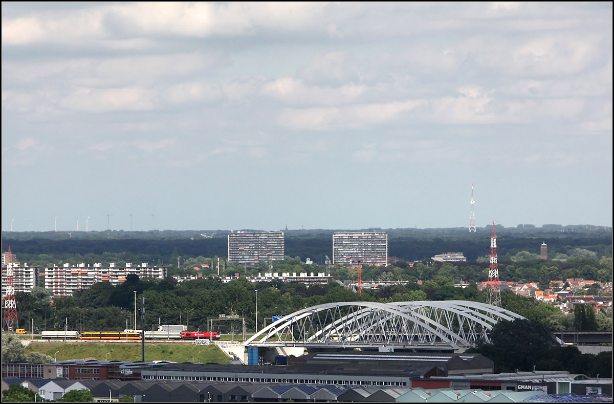 Eine Karlsruher Straßenbahn in Antwerpen -

Blick vom Dach des MAS (Museum aan de Stroom) auf die von Norden kommende Bahnstrecke in Antwerpen mit den Bogenbrücken über den Albertkanaal. Der Güterzug überführt vermutlich eine neue Straßenbahn vom Typ NET 2012 von Voosloh-Kiepe nach Karlsruhe.

22.06.2016 (M)