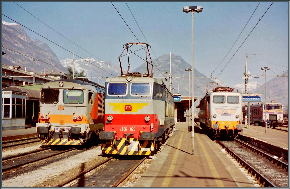 Eine kleine, zufällige Lokparade in Domodossola: Links die FS D 345 1046 mit einem Regionalzug nach Novara, in der Mitte die E 656 025 und im Hintergrund rechts im Bild die FS E 646 151. Dazu ist ganz links im Bild noch ein FS-Steuerwagen zu sehen. Zum Zeitpunkt der Aufnahme war ein solch buntes Betriebsgeschehen in Domodossola normaler Alltag. 

März 1998