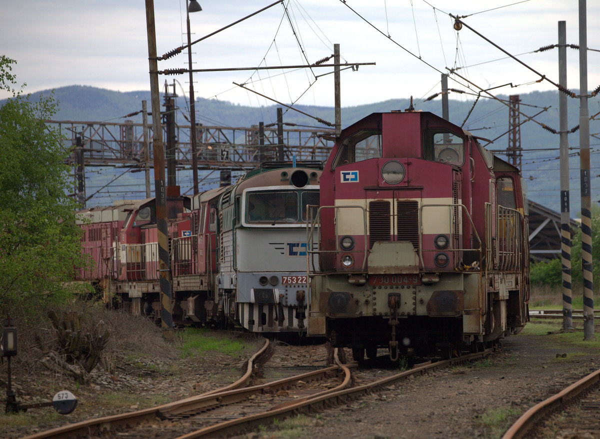 Eine Lok der BR 730, die  730  004-9  führt  den Schrottlokzug auf dem anderen Gleis an.
753 22X wird verdeckt. 24.04.2018 16:57 Usti nad Labem.
