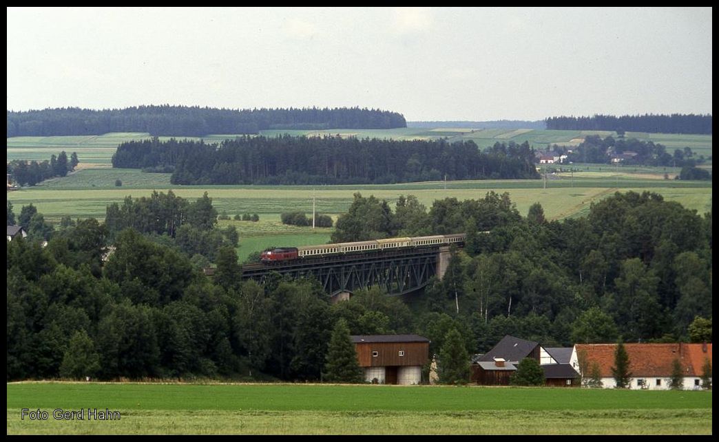 Eine mir unbekannte 218 der DB war am 10.7.1992 um 11.53 Uhr mit dem D 2603 bei Oberthölau kurz vor Marktredwitz mit einer Reichsbahn Garnitur in Richtung Nürnberg unterwegs.