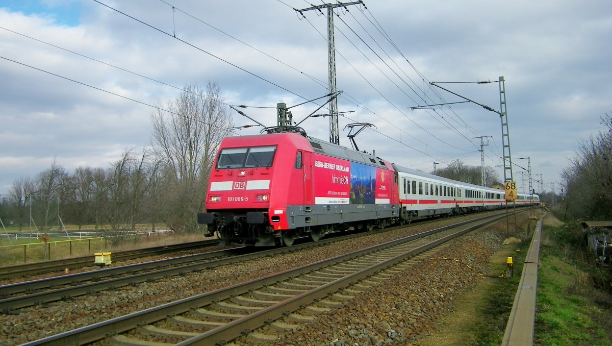 eine der neuen Schweiz-Werbeloks, die 101 006-5, fährt am 19.2.2014 mit ihrem IC vorbei am Bahnübergang in Röderau bei Riesa