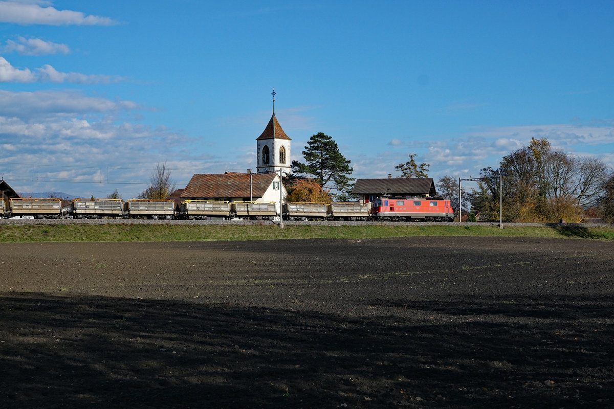 Eine nicht erkennbare Re 420 mit einem Aushubzug beim Passieren der Kirche Aegerten am 12. November 2018.
Foto: Walter Ruetsch