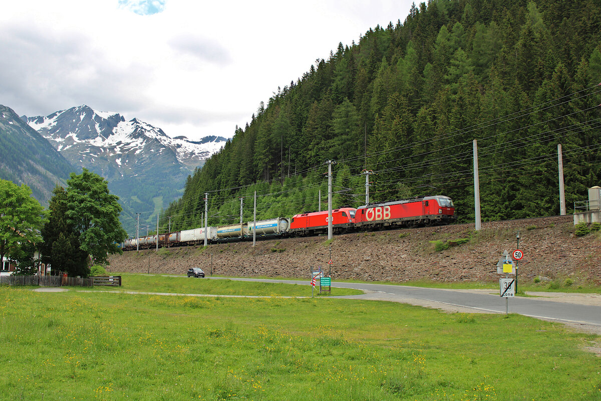 Eine ÖBB 1293 und eine 1116 ziehen einen KV-Zug über die Tauernbahn in Richtung Süden und erreichen hier gerade Mallnitz-Obervellach. (10.06.2023)