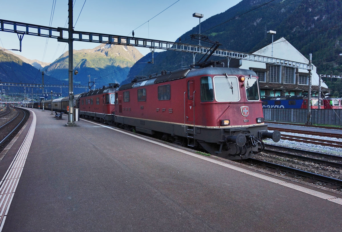 Eine Re 10/10, bestehend aus den Lokomotiven Re 4/4 II 11263 und Re 6/6 11627  Lutterbach-Attisholz , fährt mit einem Güterzug in den Bahnhof Erstfeld ein.
Aufgenommen am 20.7.2016.