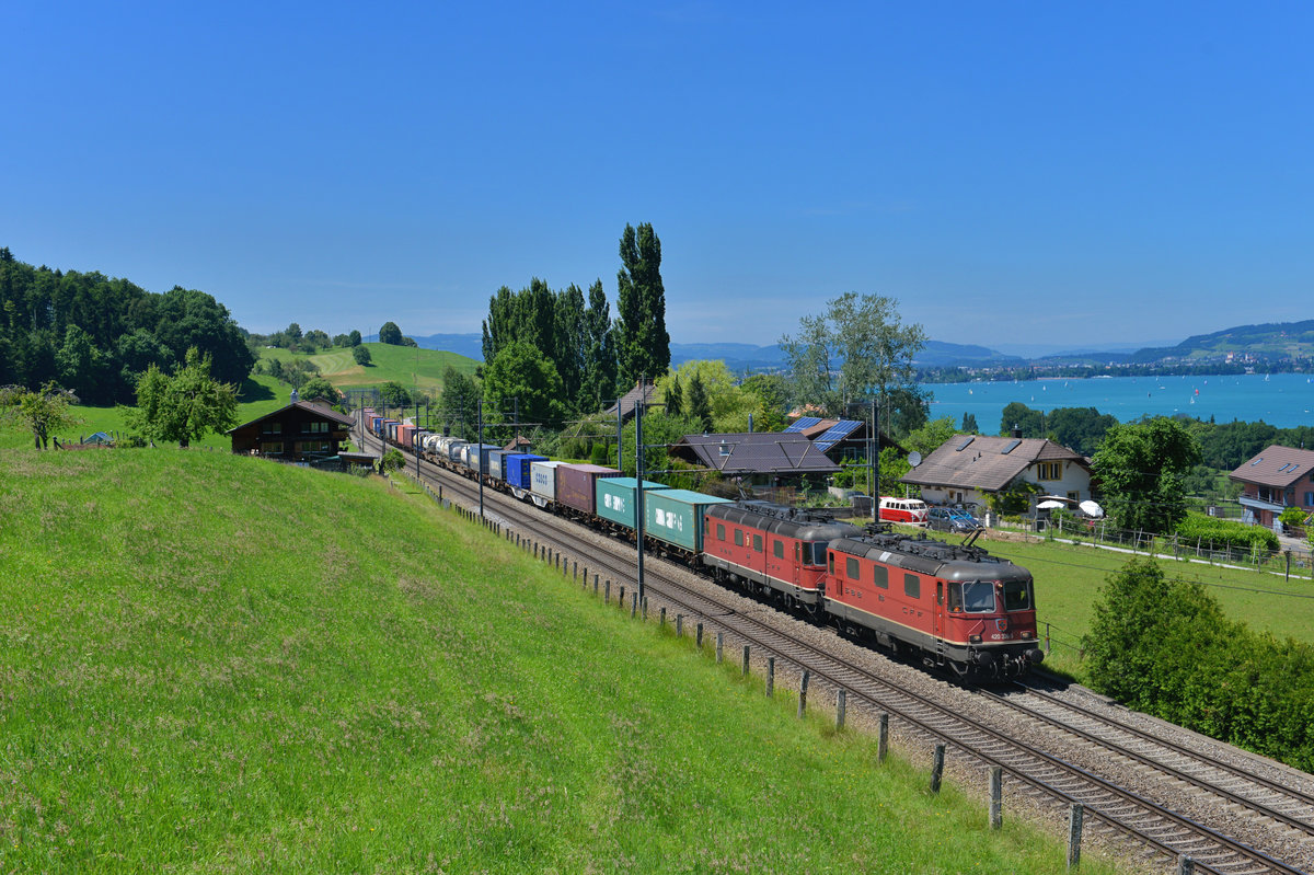 Eine Re 10/10 mit einem Containerzug am 11.06.2017 bei Spiez. 