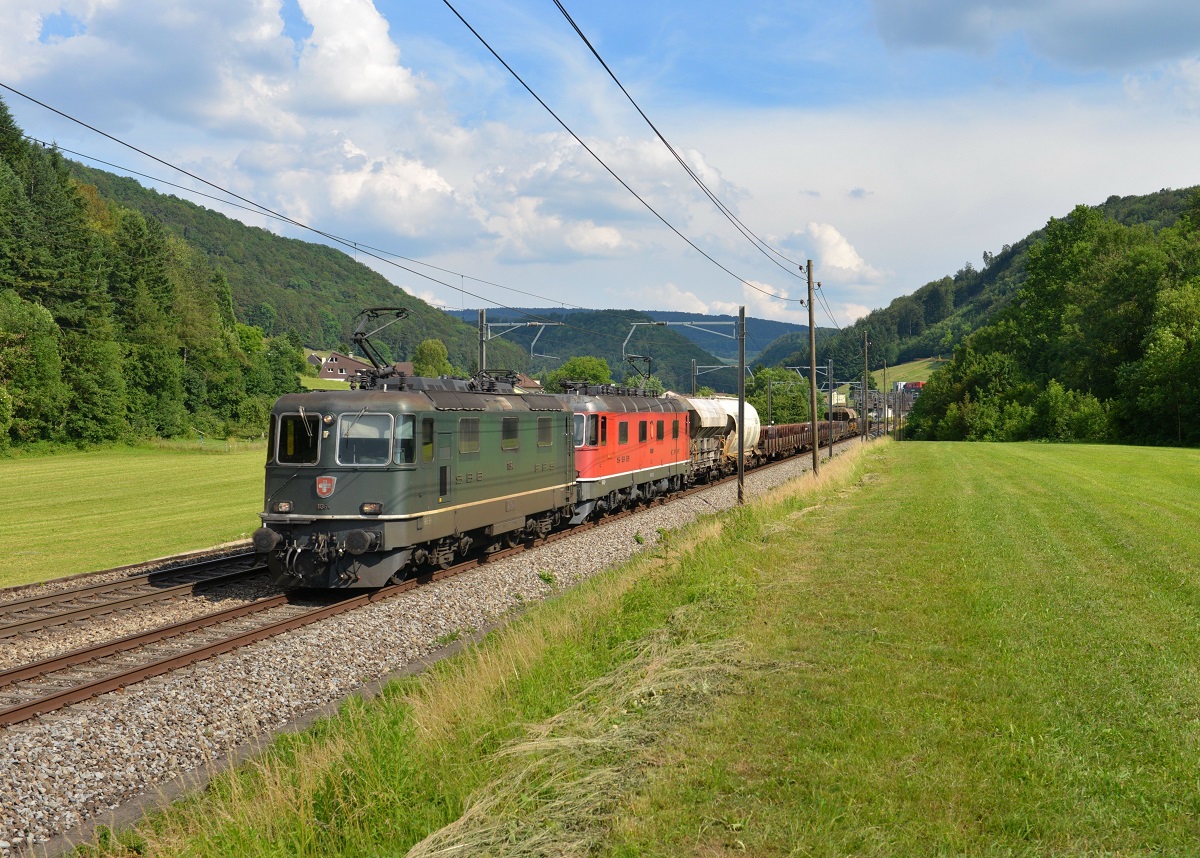 Eine Re 10/10 mit einem Güterzug am 18.06.2014 bei Tecknau.