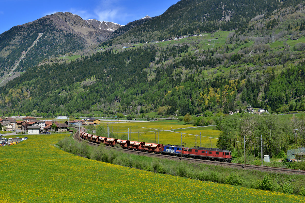 Eine Re 10/10 mit einem Kieszug am 20.05.2016 bei Ambri. 