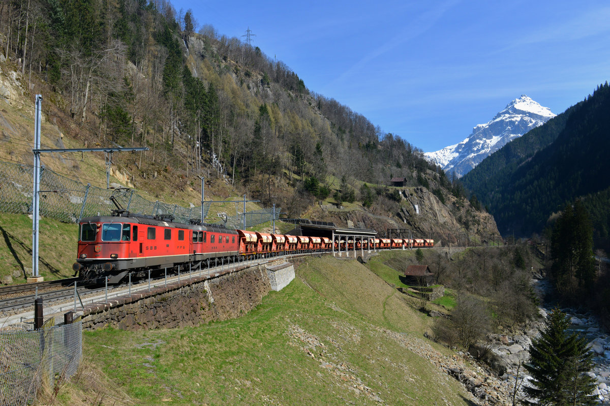 Eine Re 10/10 mit einem Kieszug am 10.04.2015 bei Gurtnellen. 
