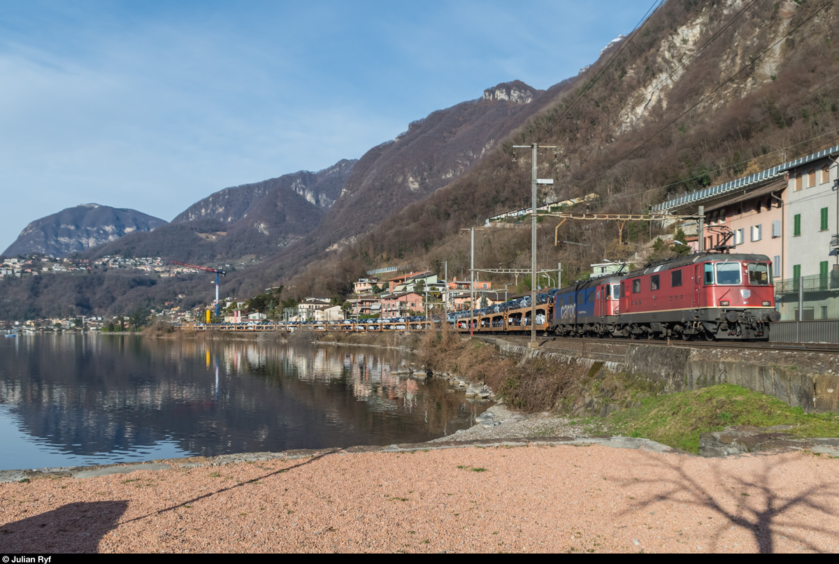 Eine Re 10/10 schleppt bei Capolago einen Autozug mit neuen Fords in Richtung Italien. 20. Februar 2016.