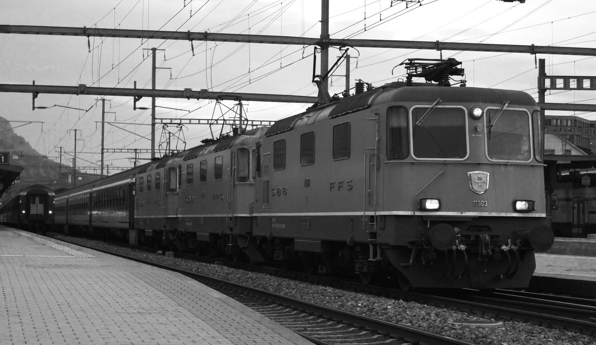 Eine sehr seltene Dreifachtraktion mit den Loks SBB Re 4/4 II Nr. 11303, SBB Re 4/4 II Nr. 11152 und SBB Re 4/4 II Nr. 11155 vorgespannt vor einem IR von Zürich HB nach Basel SBB kommt im Bild auf Gleis 2 im Bahnhof Brugg an. Links im Bild sieht man noch den IR von Basel SBB nach Zürich HB vorgespannt mit eine Doppeltraktion von SBB Re 4/4 II welches gerade abfährt. 
Es sollte eigentlich mein Zug zum HB Zürich sein, aber eine Dreifachtraktion durfte ich nicht einfach so bewusst mitansehen wie er mir vorbeifuhr... So hatte ich mit Absicht meinen Zug verpasst. Freitag, 20. Oktober 2017