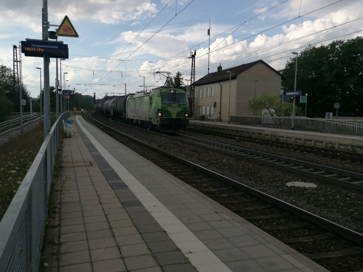 Eine Siemens Vectron von RheinCargo hat gerade einen Kesselwagenzug die Geislinger Steige hochgezogen und fährt nun durch den Bahnhof Amstetten richtung Ulm. Sie bekam Schubunterstützung von DB 185 200-3. Das Bild ist während eines Regenschauers entstanden (30.07.2022)