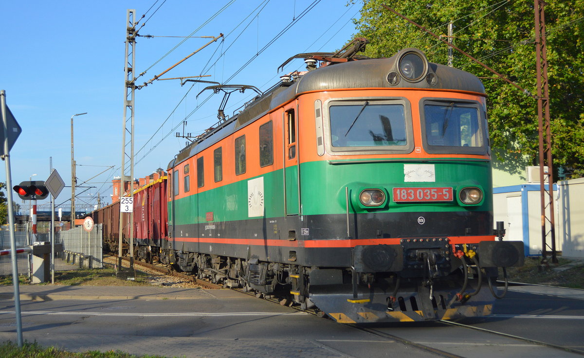 Eine slowakische Gleichstrom-Lok in Diensten von Rail Polska, die  183 035-5  (NVR:  91 56 6 183 035-5 SK-ZSSKC ) mit einem Ganzzug offener Drehgestell-Güterwagen nach der Durchfahrt Bf. Kostrzyn am 30.09.20