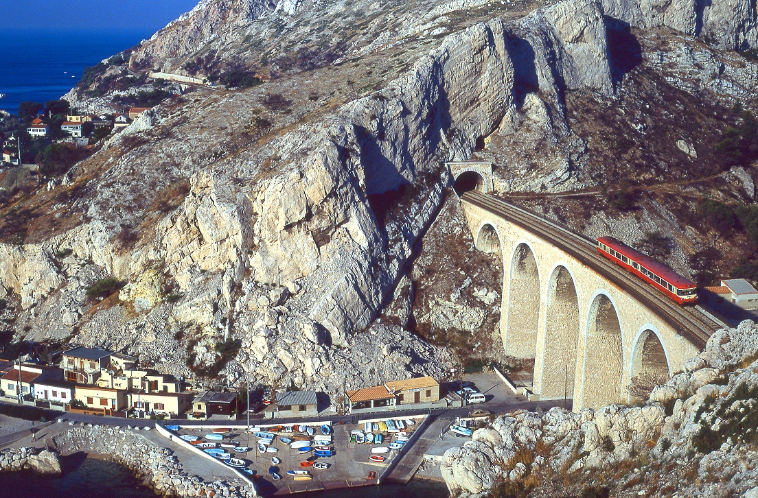 Eine der spektakulrsten Strecken berhaupt: die Linie Martigues - Marseille entlang der Cte Bleue. Calanques werden die engen, steilwandigen Buchten dieser Region genannt. Eine solche berquert eine  Caravelle  bei La Vesse am 04.09.1990 mit Zug 56135.