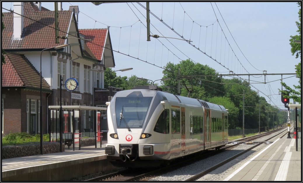 Eine Stadler GTW Garnitur rauscht hier im Bild gerade durch den Bahnhof von Voerendaal nach Heerlen.Diese Aufnahme entstand am 25.Juni 2015 in Südlimburg in den Niederlanden.