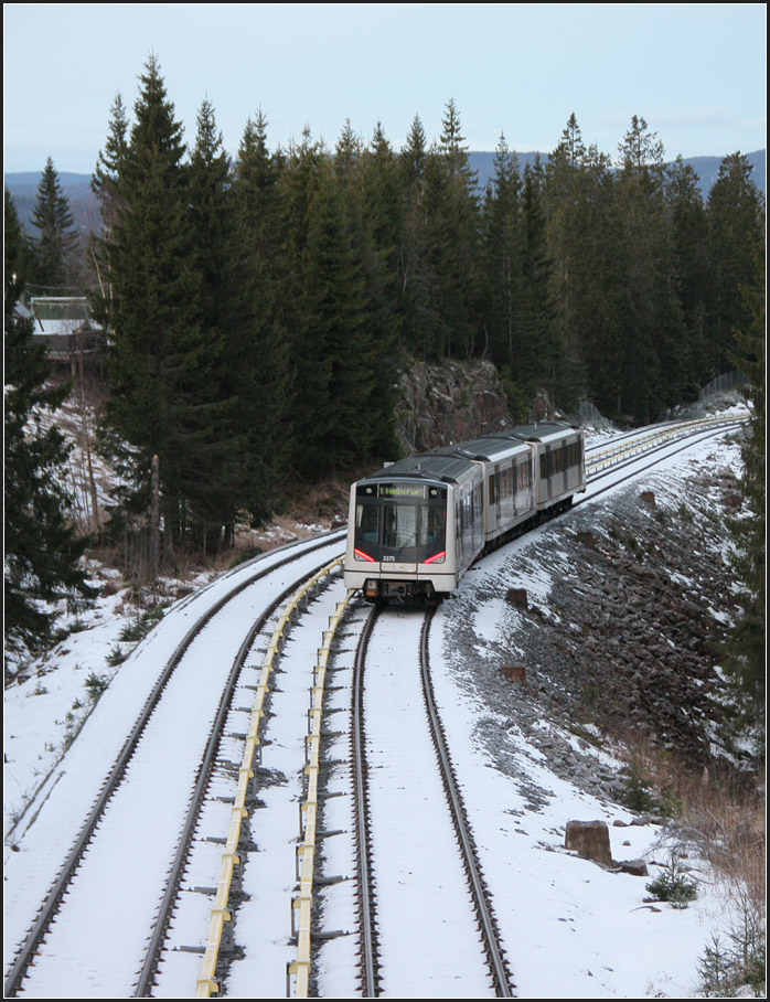 Eine U-Bahn auf Talfahrt -

Der dreiteilige Zug hat die Station Voksenkollen verlassen und rollt hier noch in freie Natur hinab gen Oslo. Hier oben auf ca. 460 Meter Höhe lag auch noch etwas Schnee.

30.12.2013 (M)