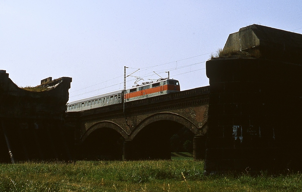 Eine unbekannte 111 überquert um 1981 die Vorlandbrücken der Rheinbrücke von Neuss nach Düsseldorf, im Vordergrund die Reste der alten, südlichen gelegenen Vorlandbrücke, die im 2. Weltkrieg zerstört und nicht wieder aufgebaut wurde