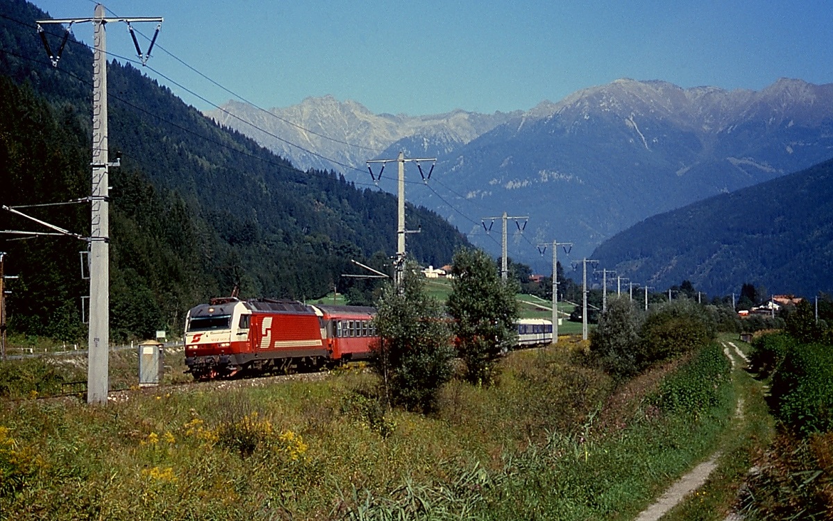 Eine unbekannte 1822 ist im Juni 2001 mit einem Korridorzug und einem 4030 im Schlepp bei Kleblach-Lind in Richtung Lienz unterwegs. Durch die massiven Betonmasten hat die Drautalbahn einiges von ihrem früheren Charme verloren.