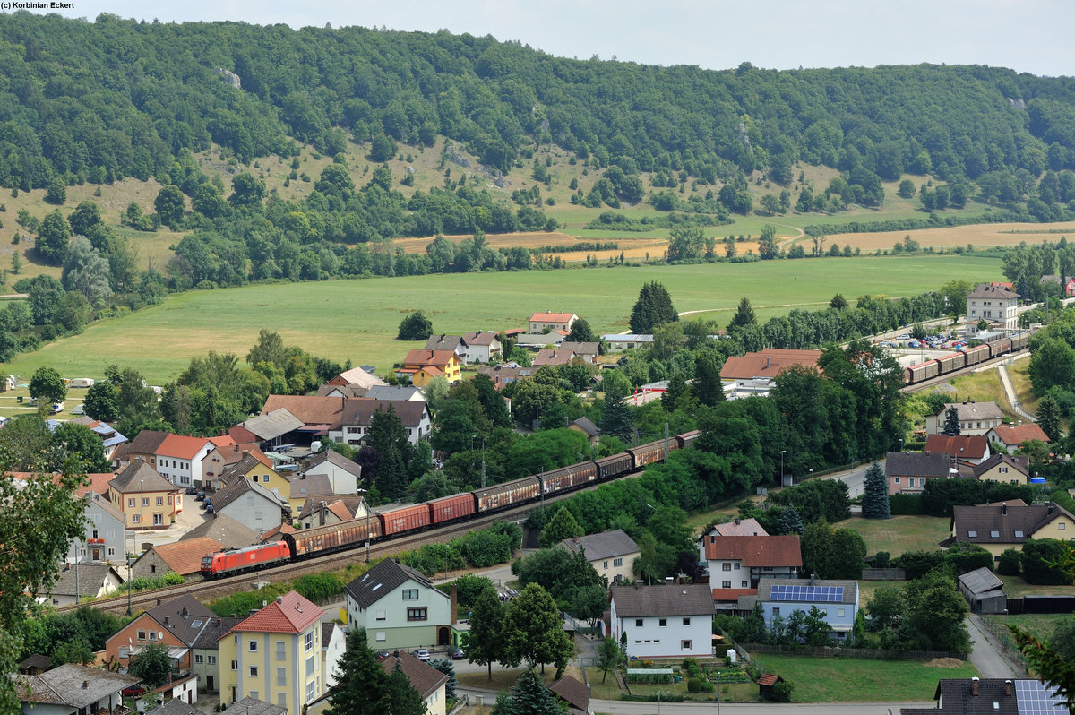 Eine unbekannte Br 185 mit einem Güterzug bestehend aus mehreren Schiebewandwagen bei der Durchfahrt in Dollnstein Richtung Treuchtlingen, 16.07.2015