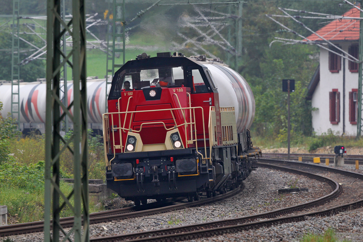 Eine V180 der Hohenzollerischen Landesbahn kommt mit einem Holcim Zementwagenzug
bei Hattingen vorbeigerauscht.Bild vom 9.9.2104