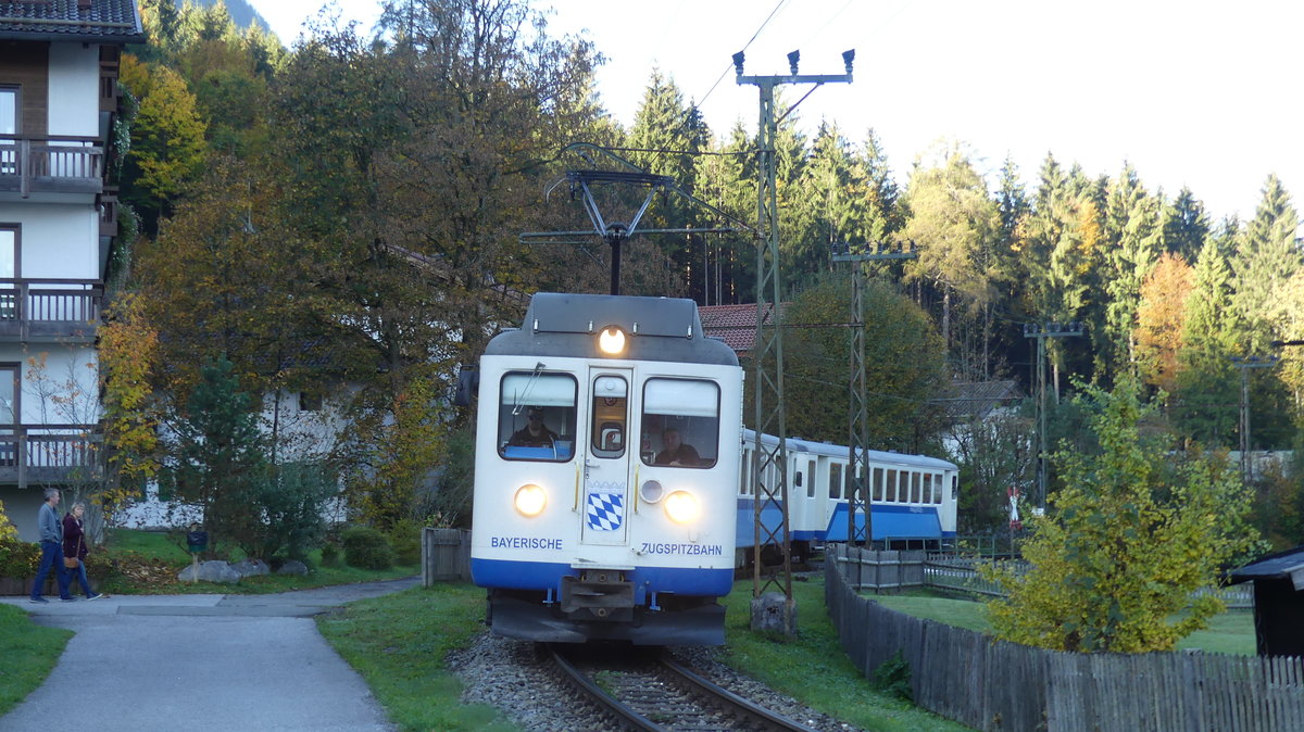 Eine Zugspitzbahn rattert durch Hammersbach. Der Zug bestehend aus dem Triebwagen 309 und den Beiwagen 211 und 213 ist in Richtung Garmisch-Partenkirchen unterwegs. Aufgenommen am 9.10.2018 9:40