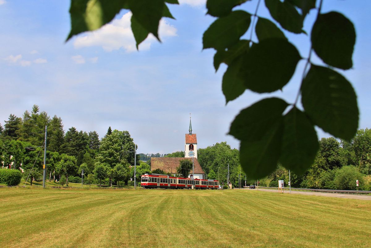 Eine zwar oft photographierte, aber stets reizvolle Stelle auf der Waldenburgerbahn. Mit Pendelzug (Triebwagen 15) bei der Kirche unterhalb Oberdorf-Winkelweg. 22.Juni 2017
