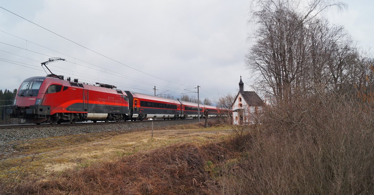 Einen Farbakzent in der kahlen Vorfrühlingslandschaft setzt der RJX 863 von Bregenz nach Flughafen Wien, der von 1116 206 bei Brixlegg Richtung Wörgl geschoben wird. (07.03.2020)
