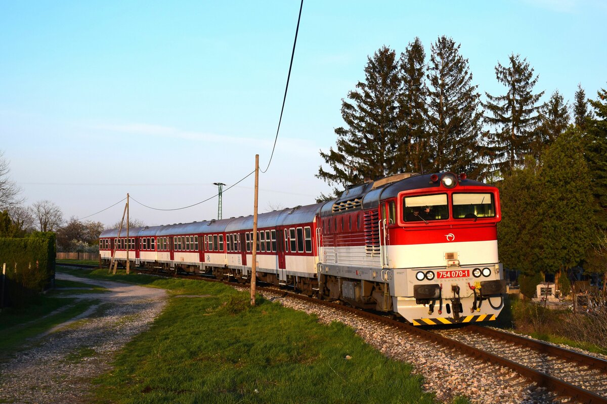 Einer der ersten Tage in diesem Jahr, an denen dieser Zug fotografiert werden kann. 
Die 754 070-er Taucherbrille ist auf dem Weg von Komárno (Komárom) nach Dunajská Streda (Dunaszerdahely) kurz vor Komárno Nová Stráž (Örsújfalu) mit dem Zug Os4342.
05.04.2023.