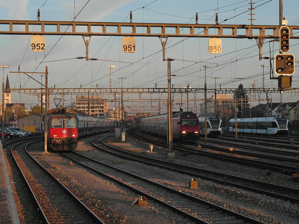 Einer fhrt - Drei stehen. Whrend IC 732 auf der Fahrt von St. Gallen nach Genve-Aroport am 01.11.2014 den Bahnhof Wil (SG) verlsst, bleiben eine 420er und zwei RABe 526 stehen.