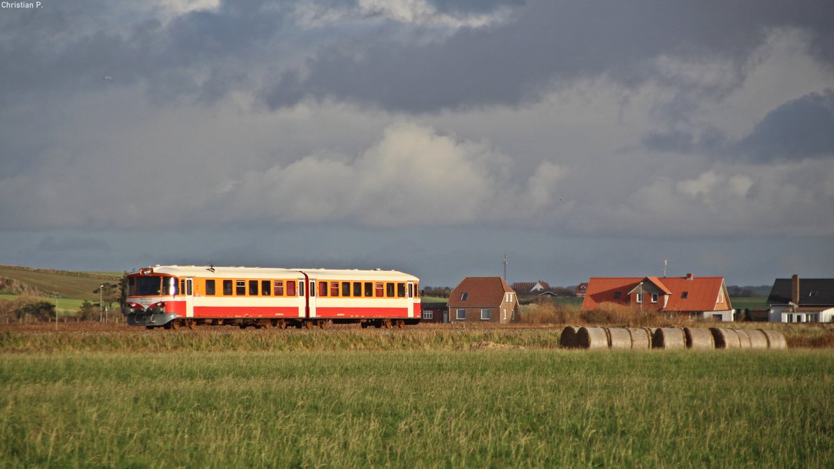 Eines meiner 2 Hauptmotive war das bild mit dem Kirchturm von Strande aus, dazu bot sich der R 965 vom Sonnenstand her.
Fast hätte ich im Wolkenlotto verloren als sich grade gechzeitig noch einige strahlen erbahmten.
Der R 965 wurde vom YS602 014-1/YM601 014-2  Tangen  gefahren.
Die in Dänemark als ML geführten Y-Tog werden im Volksmund auch  Lynette  genannt, was zu Deutsch Blitzchen bedeutet. Die ab 1965 von der Waggonfabrik Uerdingen gebauten Triebwagen fanden bei einer vielzahl von Dänischen Privatbahnen großen anklang. Mittlerweile hat nurnoch die Midtjyske Jernbaner (ehemals Lemvigbanen) die Fahrzeuge im bestand. In derem Fuhrpark sind auch Einheiten anderer, mitlerweile nicht mehr existenten Bahnen zu finden bzw. ausgemusterte Fahrzeuge anderer Bahnen. Jedoch ab 2019/2020 soll die Ära der  Lynetten  im Plandienst endgültig vorbei sein, die Midtjyske Jernbaner hat neue Fahrzeuge in Auftrag gegeben. Das praktische Modulare System (YM-YM / YM-YS / YM-YP-YM / YM-YP-YP-YM) der verlängerbaren einheiten hat sich leider nicht groß durchgesetzt. (YM=Motorwagen, YS=Steuerwagen, YP=Mittelwagen) 