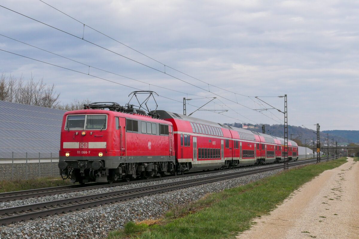 Eines der wenigen noch verbliebenen Gnadenbrote für die Baureihe 111, ist der Ringzug West wenn dort mal eine Traxx ausfällt. Dies war auch am 10.04.2021 der Fall und so musste 111 066 ran. Hier passiert sie mit einem RE nach Nürnberg Hbf die Fotografen in Pölling.