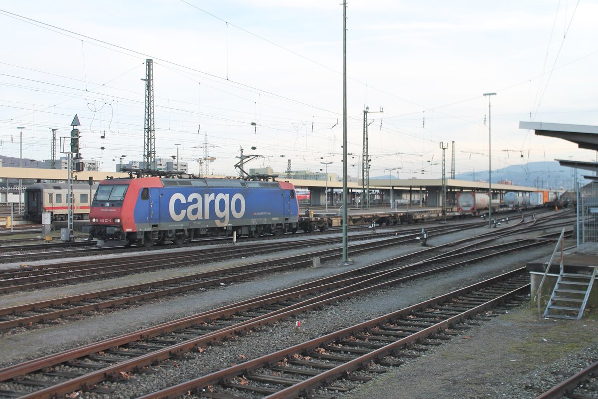 Einfahrt am 02.02.2017 von Re 482 027-0 mit einem bunten Containerzug auf Gleis 1 in Basel Bad Bf in Richtung Norden.