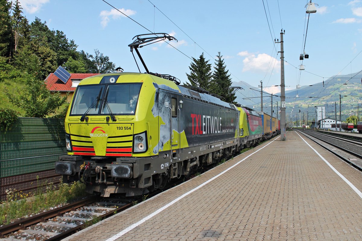 Einfahrt am Nachmittag des 02.07.2018 von ATLU/TXL 193 554  TXLEITWOLF  zusammen mit ATLU/TXL 193 557  OUR DAILY HEROS: FOR YOU ONTRACK  und deren KLV nach Verona Q. E. aufs Überholgleis von Fritzens-Wattens, um dort von einem Nahverkehrszug überholt zu werden.