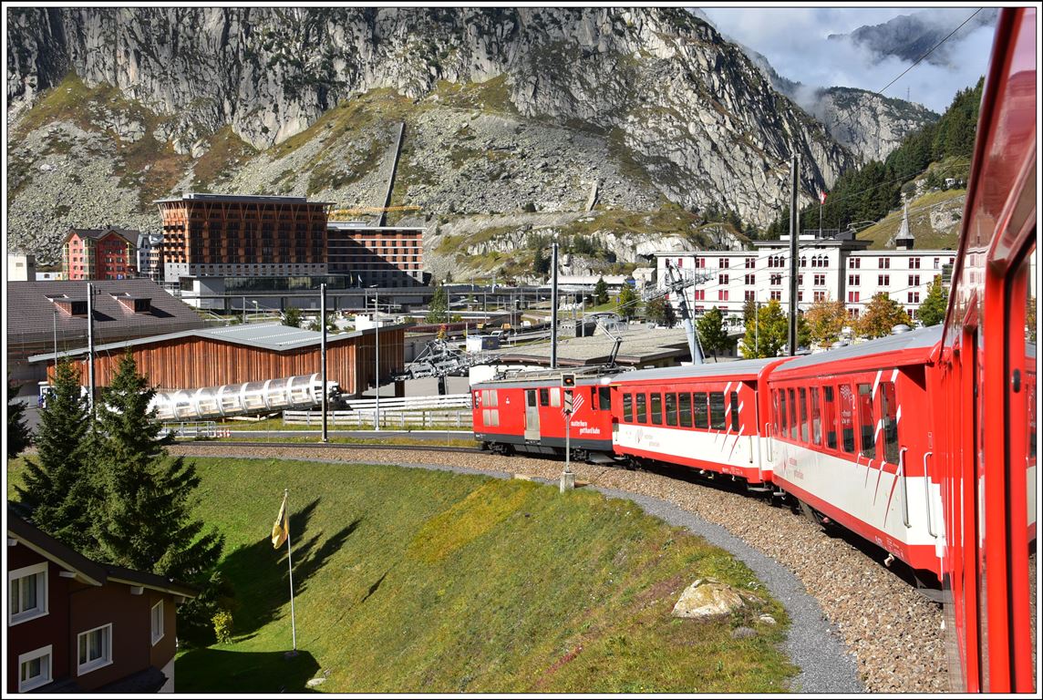 Einfahrt in Andermatt von R835 mit Deh 4/4 24. Im Vordergrund ist die neue Station der Gondelbahn zum Nätschen zu sehen, dahinter das Radisson Hotel von Sami Sawiris und rechts davon, etwas weniger bequem, die Kaserne der Schweizer Armee. (10.10.2019)