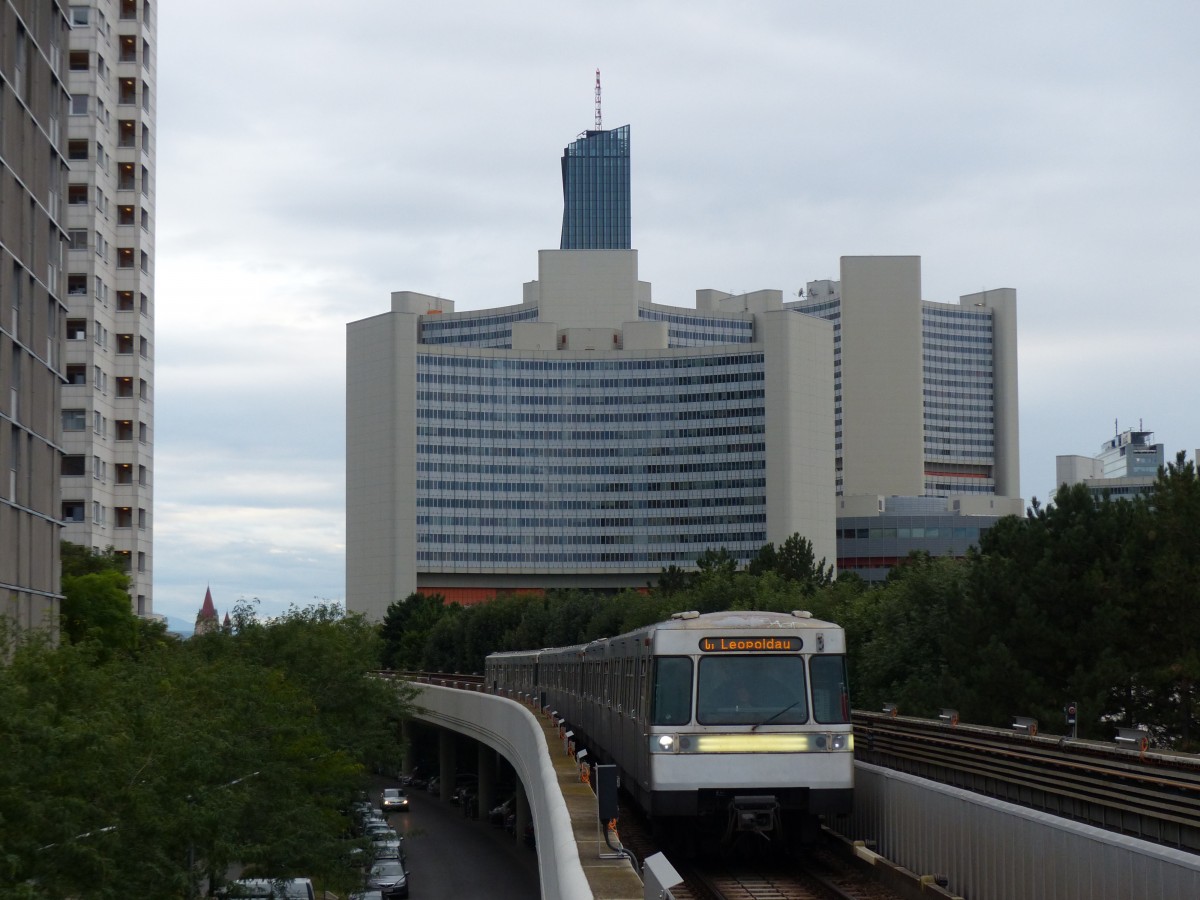 Einfahrt einer U1 nach Leopoldau in der Station Alte Donau am 25.8.2015. Im Hintergrund ist das Vienna International Centre (VIC) zu sehen. 