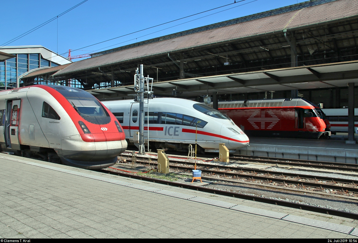 Eingekesselt vom Fernverkehr der SBB steht 403 536-6 (Tz 336  Ingolstadt ) als ICE 108 (Linie 43) nach Köln Hbf (D) in seinem Startbahnhof Basel SBB (CH) auf Gleis 12.
Links daneben erkennt man RABDe 500 043-8  Harald Szeemann  als IC 1618 (IC 51) nach Biel/Bienne (CH) auf Gleis 14, im rechten Teil ist noch eine Re 460 als IR 2469 (IR 27) nach Luzern (CH) zu erahnen.
Alle Züge befinden sich hier in ihrem Startbahnhof.
[24.7.2019 | 10:56 Uhr]