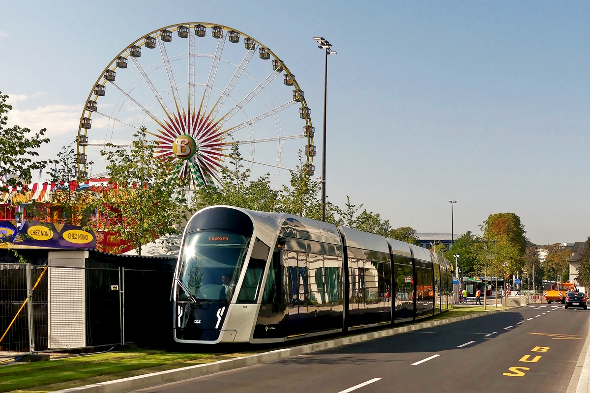 Eingleisig vorbei an der Kirmes - Die CAF Urbos von LUXTRAM S.A. fahren auf einem Gleis in der Alle Scheffer in Luxembourg-Limpertsberg am grten luxemburgischen Rummel vorbei und bringen tausende von Besuchern auf die  Schueberfouer . Das Riesenrad weckt bei den Fotografen das Verlangen mal etwas andere Tram Fotos zu machen. 😊 23.08.2018 (Jeanny) 