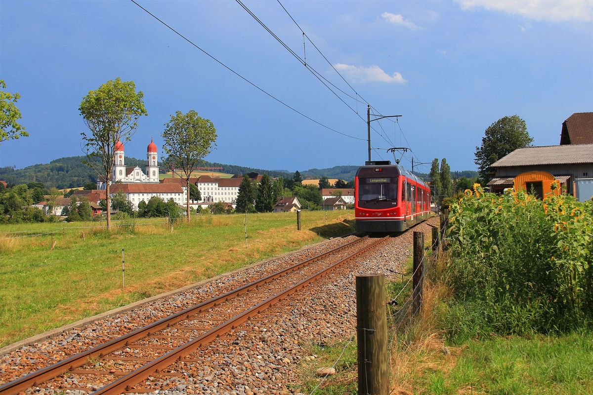 Einst führte eine Lokalbahn von Langenthal über St.Urban nach Melchnau, heute endet der modern geführte Betrieb in St.Urban. Entlang der Strecke stehen bemerkenswert schöne Bauten, doch hier in St.Urban befindet sich das eindrucksvolle Kloster jenseits der Kantons- und Konfessionsgrenze. Auf der bernischen Seite der Grenze fährt der dreiteilige Triebzug 113 der Aare-Seeland Mobil seiner Endstation entgegen.
18.Juli 2017  