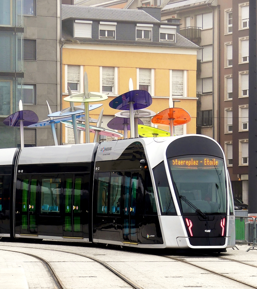 Einzig die bunten Schirme am  Perdsmaart  in Luxembourg-Ville Haute verleihen der Aufnahme von dem CAF Urbos von LUXTRAM S.A. beim Verlassen der Haltestelle Theater ein bisschen Farbe am winterlichen 28.12.2018. (Jeanny) 