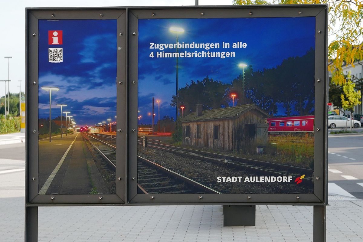 Eisenbahnknoten Aulendorf - Auf dem Bahnhofsvorplatz weist ein Schild darauf hin, dass es in Aulendorf Zugverbindungen in alle 4 Himmelsrichtungen gibt. Aufnahme vom 16.09.2019.