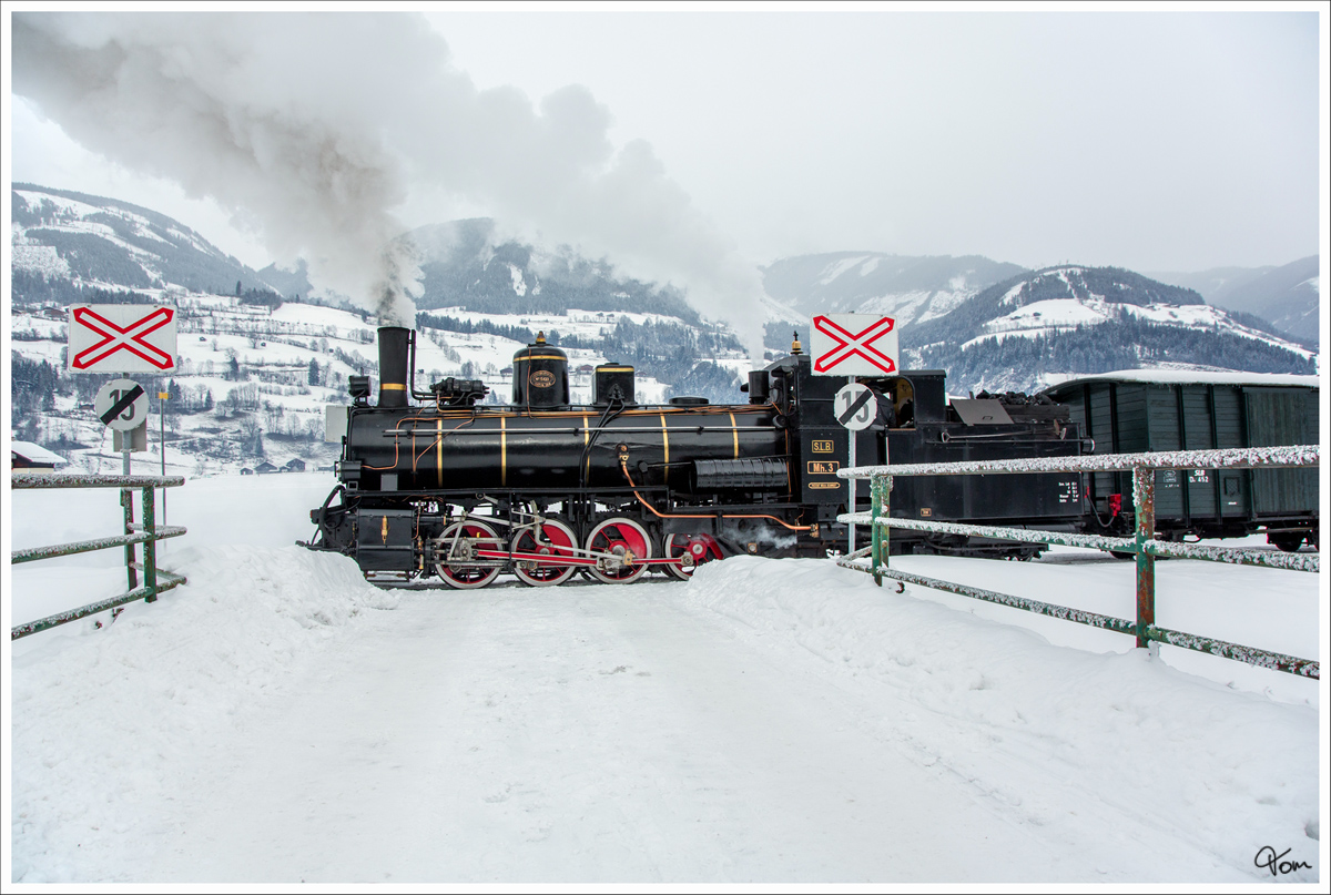 Eisenbahnkreuzung - Auf der Pinzgaubahn fährt die Dampflok MH3, mit einem Dampfsonderzug von Zell am See nach Krimml. 
Niedernsill 1.2.2015