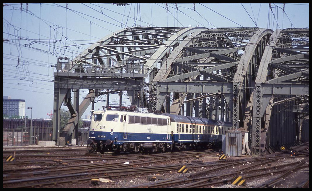 Elektrolok 110354 verlässt hier am 21.5.1992 um 15.03 Uhr mit einem Personenzug die Hohenzollernbrücke in Köln und fährt in den Hauptbahnhof ein.