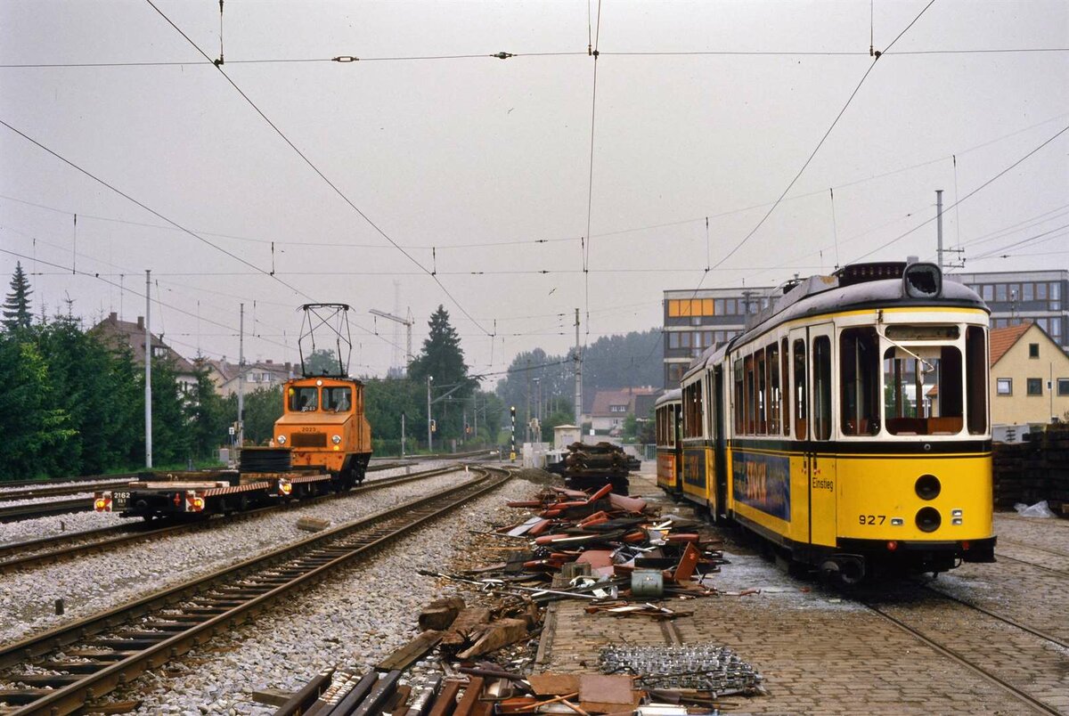 Ellok 2023 der SSB fährt am 26.07.1984 im weiteren Bereich des Möhringer Bahnhofs an DoT 4 927 und BW 1517 vorbei.
