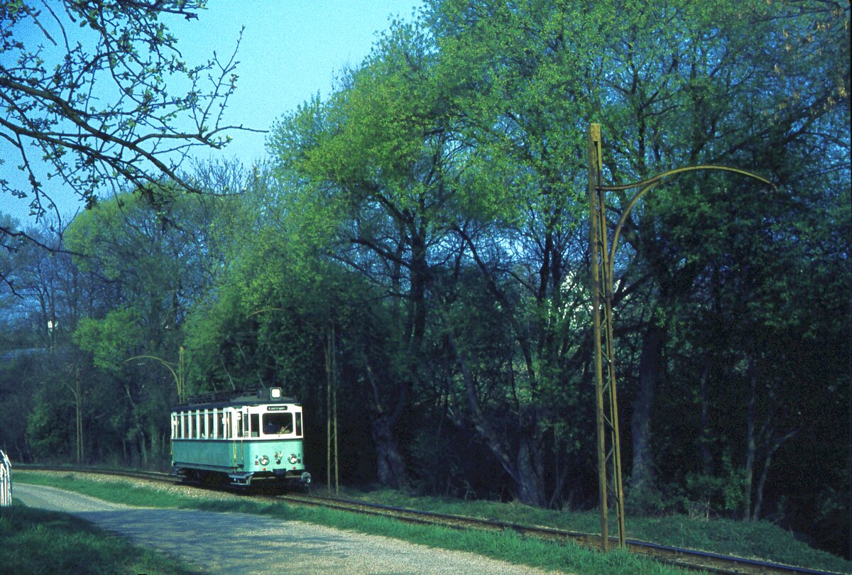 END Straßenbahn Esslingen-Nellingen-Denkendorf__Die aber auch nach Scharnhausen und Neuhausen fuhr.__Tw 2 in der Steigung von Scharnhausen kurz vor der Haltestelle 'Krähenbach'. Zwischen Nellingen und Neuhausen blieben die Oberleitungsmasten nach dem Abbau der Gleise 1982 noch bis Anfang der 90er Jahre stehen, als längst der von Neuhausen initiierte Radweg darunter entlang führte. Dann holte das Technikmuseum ‘Historama‘ Ferlach den Großteil der Masten zu sich nach Kärnten, um sie dort weiter zu verwenden. Oberhalb der ehemaligen Haltestelle ‘Lenzhalde‘ vergammelten ein Dutzend OL-Masten noch länger entlang der längst zugewachsenen Trasse. 2015 holte der Feldbahn-Freundeskreis Leutenbach-Nellmersbach die letzten 3 Masten (die nicht wie die übrigen das THW zu Übungszwecken gefällt hatte) zu sich. [Quelle: H-J. Knupfer; ‘Über Berg und Tal‘ 02.2022]__20-04-1976