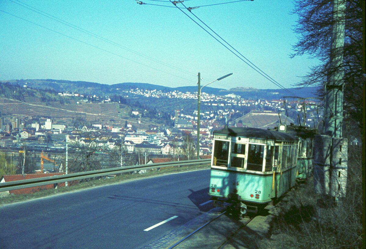 END Straßenbahn Esslingen-Nellingen-Denkendorf__Die aber auch nach Scharnhausen und Neuhausen fuhr.__Tw mit Bw 28 fährt von der Ausweichhaltestelle 'Zollberg' talwärts. Im Tal zu sehen das Bahnhofsgelände, darüber die Weinberge mit Hengstenberg-Villa, rechts davon die Frauenkirche und die Burg.__04-03-1976