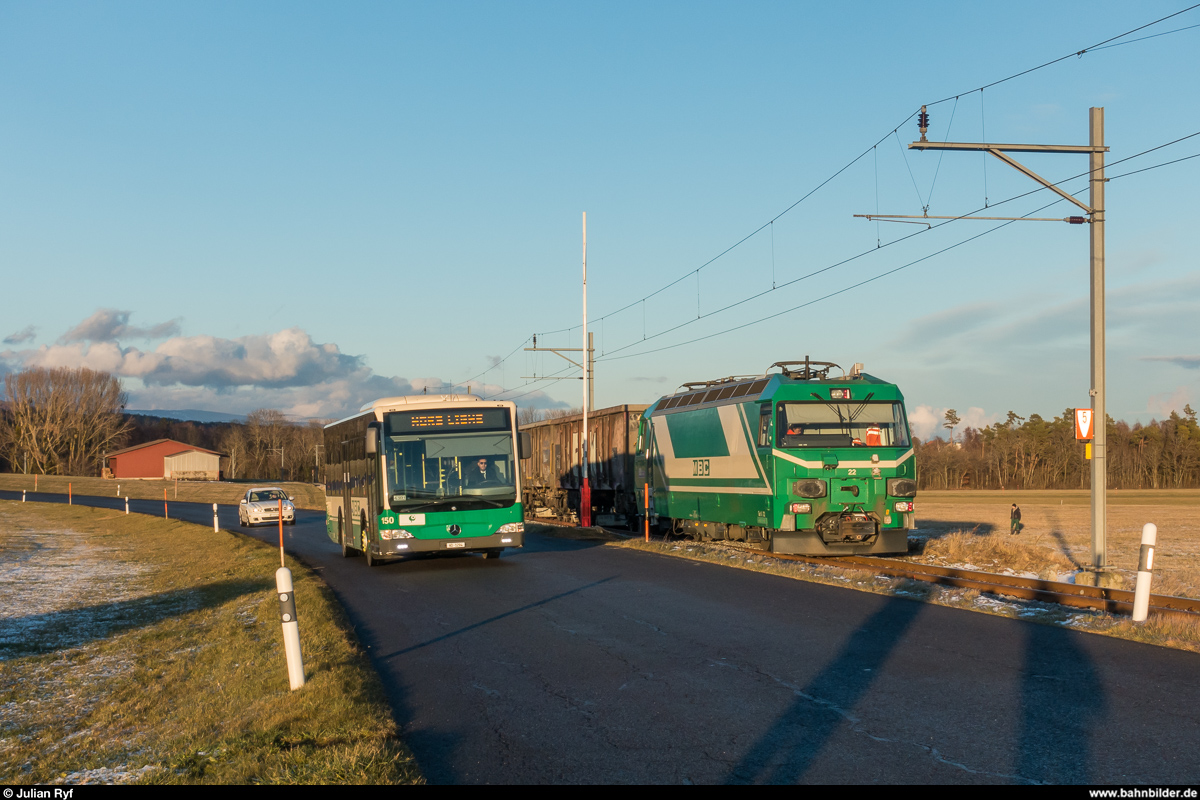Ende des Zuckerrübenverkehrs auf Schweizer Schmalspurbahnen. Bei der MBC werden dieses Jahr das letzte Mal Zuckerrüben auf der Schiene abtransportiert, ab der Saison 2018 werden die Rüben in Containern auf der Strasse nach Cossonay gebracht und dort direkt auf die Normalspur verladen.<br>
In der Woche vom 11. bis am 15. Dezember wird auf der Zweigstrecke Apples - L'Isle verladen.<br> 
Am 12. Dezember 2017 steht die Ge 4/4 22 während dem Verlad des dritten Zuges bei Montricher schön in der Abendsonne und wird dabei von einem MBC-Bus auf Leerfahrt passiert.