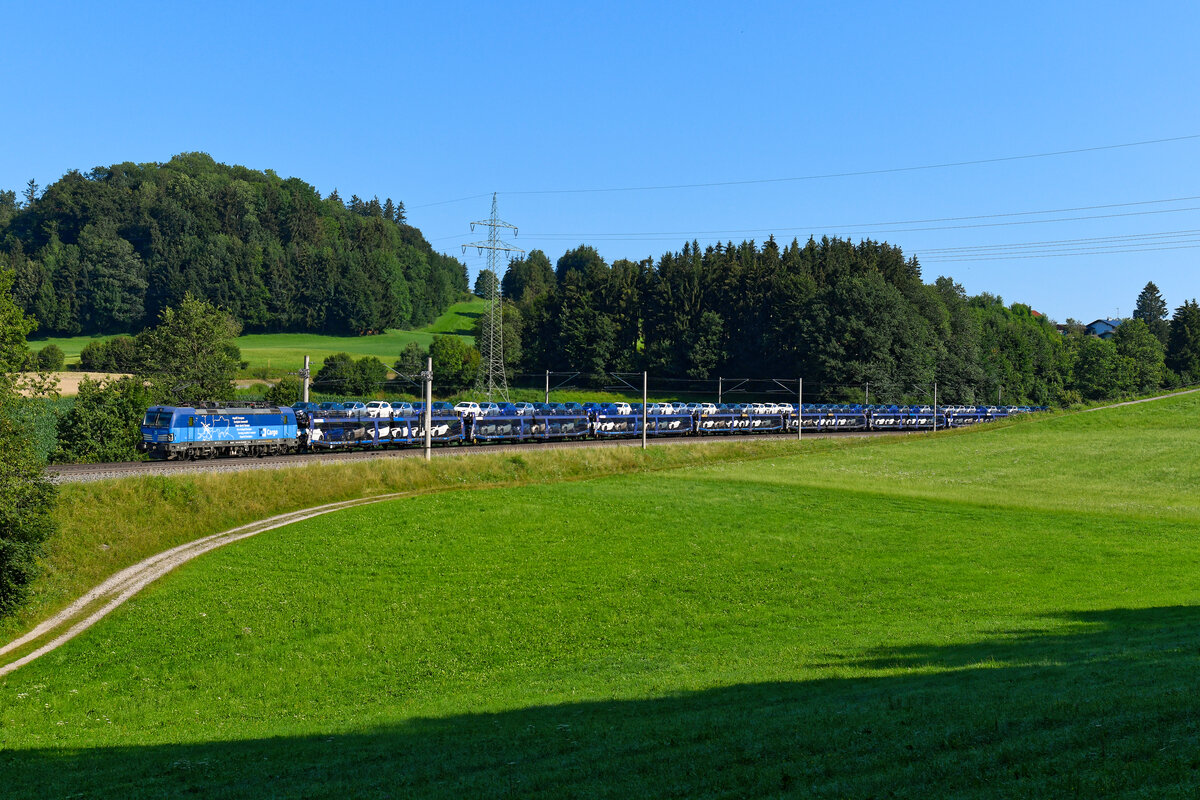 Ende Juli 2024 war der Grenzübergang bei Tarvisio Boscoverde aufgrund von Bauarbeiten für einige Tage gesperrt. Dies führte zu einigen großräumigen Umleitungen von Güterzügen. Der meiste Verkehr lief über Spielfeld-Strass und weiter über Slowenien. Einige private EVUs wählten aber auch den Weg über den Brenner und sogar über das Deutsche Eck. Somit gab es im Chiemgau einige interessante zusätzliche Züge zu sehen. So z.B. einen Containerzug mit Vectrons der PKP bespannt, oder auch einen KLV-Zug mit Loks von Budamar. Hiervon waren mir leider keine Fotos vergönnt. Am 21. Juli 2024 konnte ich aber zumindest die 383 011 von ČD Cargo vor dem SGAG 48149 von Kolín seř.n. nach Alessandria SM fotografieren. Hierbei handelte es sich um einen GEFCO-Autotransportzug, mit dem Toyotas vom tschechischen Produktionsort nach Italien gebracht wurden. Die Aufnahme entstand bei Axdorf im Chiemgau. An dieser Stelle lag die Leistung halbwegs gut im Licht. 
