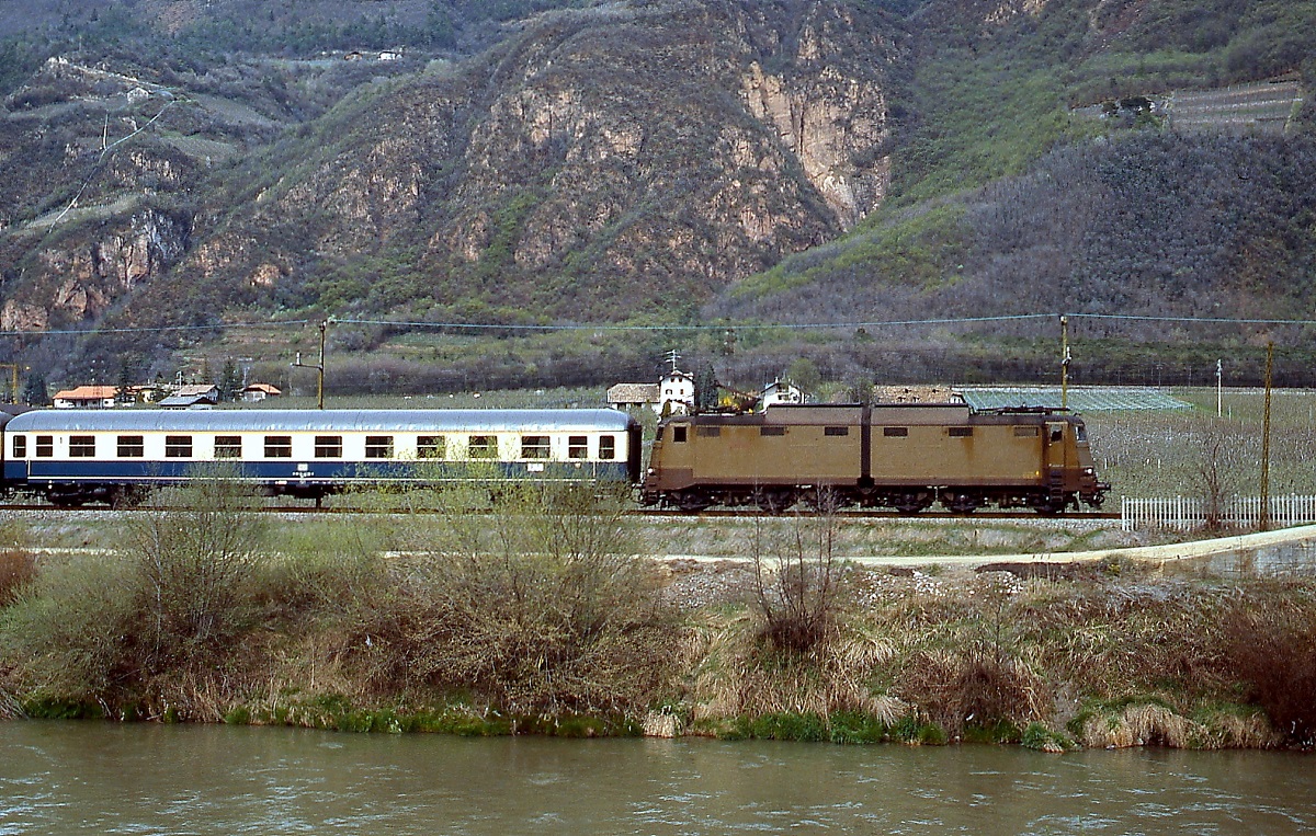 Entlang der Etsch ist eine E 636 mit einem D-Zug nach Deutschland im März 1985 zwischen Merano/Meran und Bolzano/Bozen unterwegs