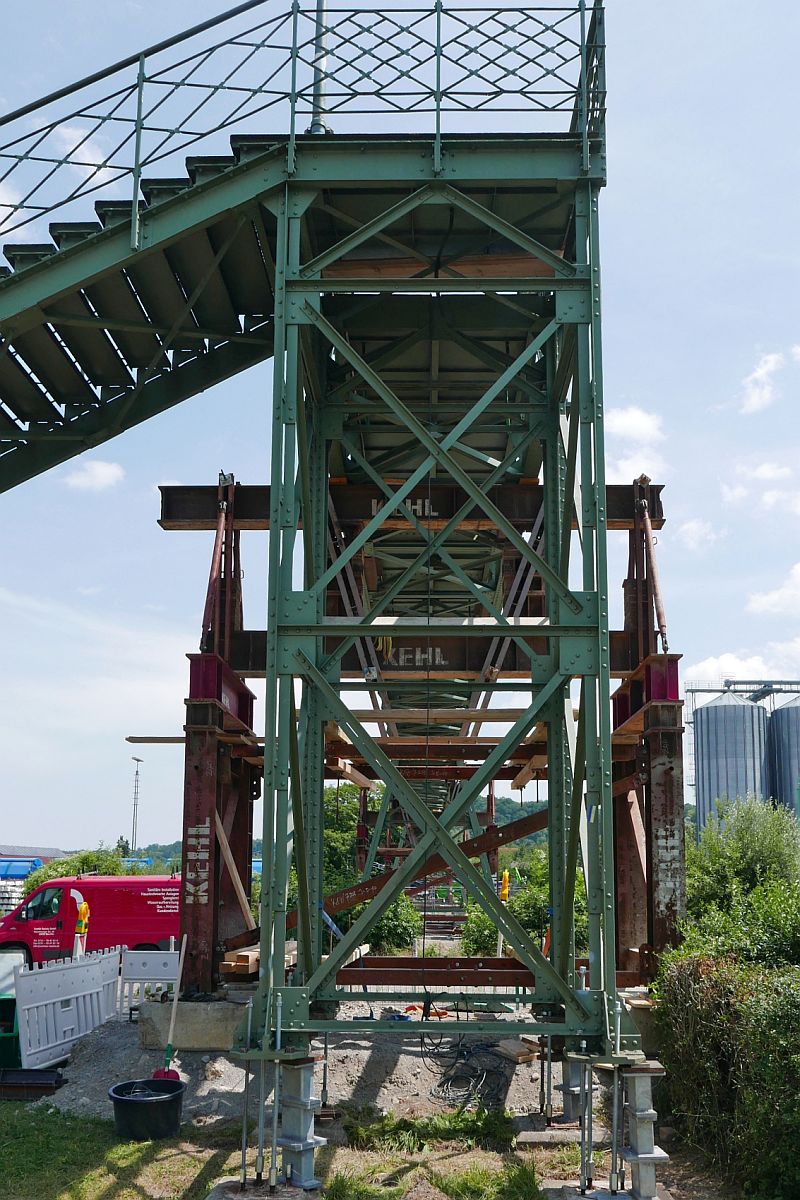 Erhhung Fugngersteg in Biberach (Ri) / (||) - Mit mehreren Hydraulikzylindern verteilt auf alle Sttzen wurde der Steg ber die Bahnlinie Ulm - Friedrichshafen um 68 cm Zentimeter angehoben. Am 01.07.2019 wurde ein weiterer Teilschritt der Erhhung von dem am Steg vorbeifhrenden und nicht abgesperrten Gehweg aufgenommen.